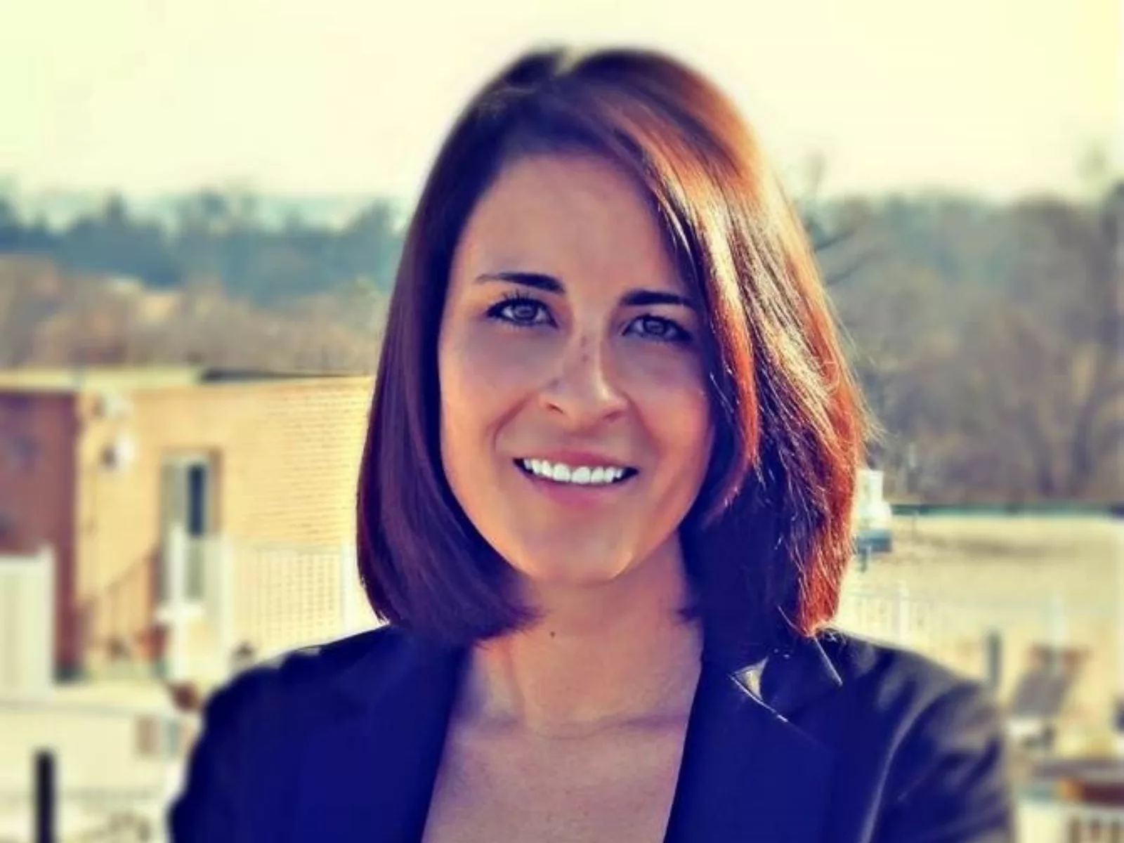 Kate Keith standing in front of city landscape.