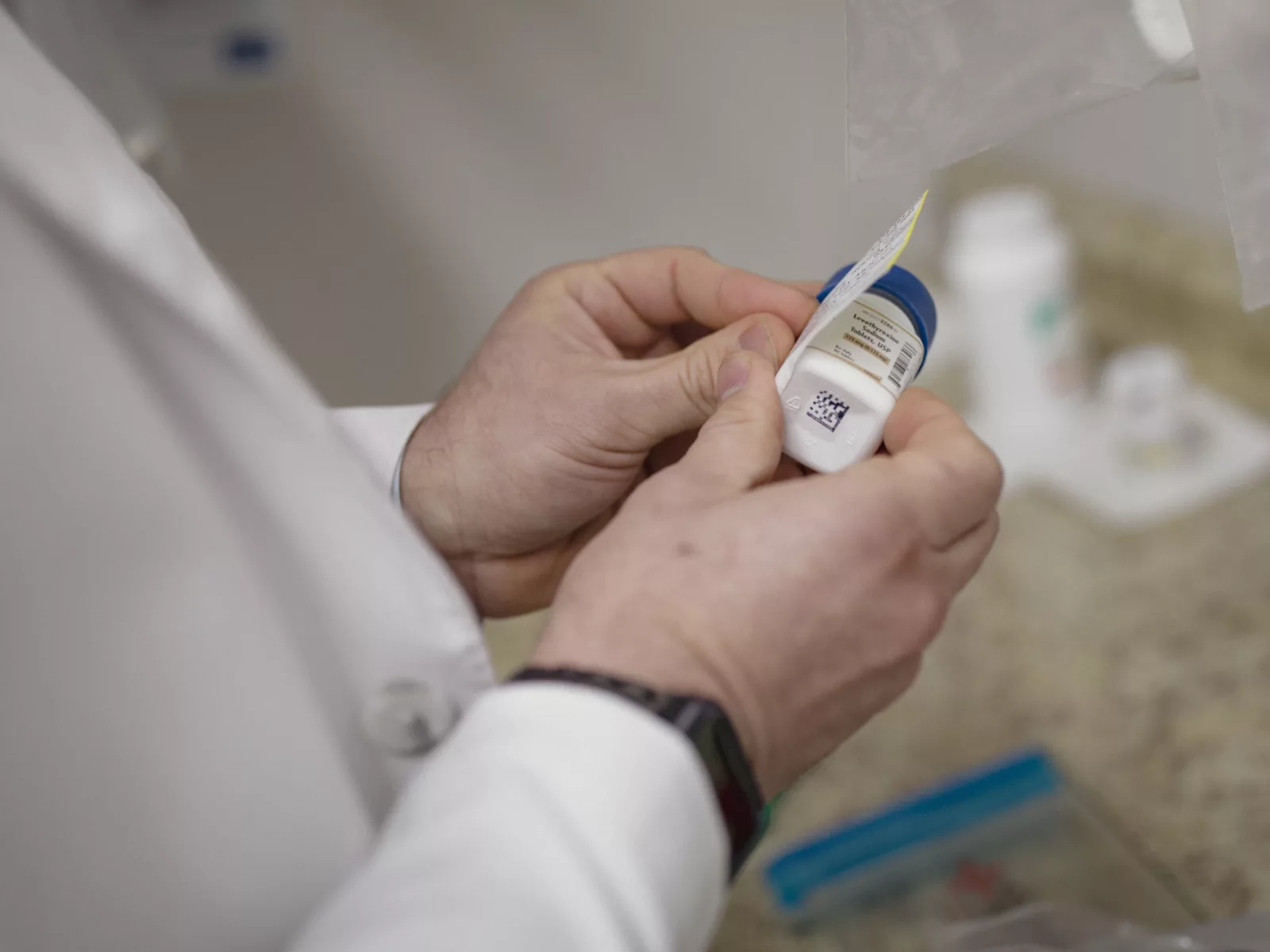 Pharmacist adds label to a bottle of pills.