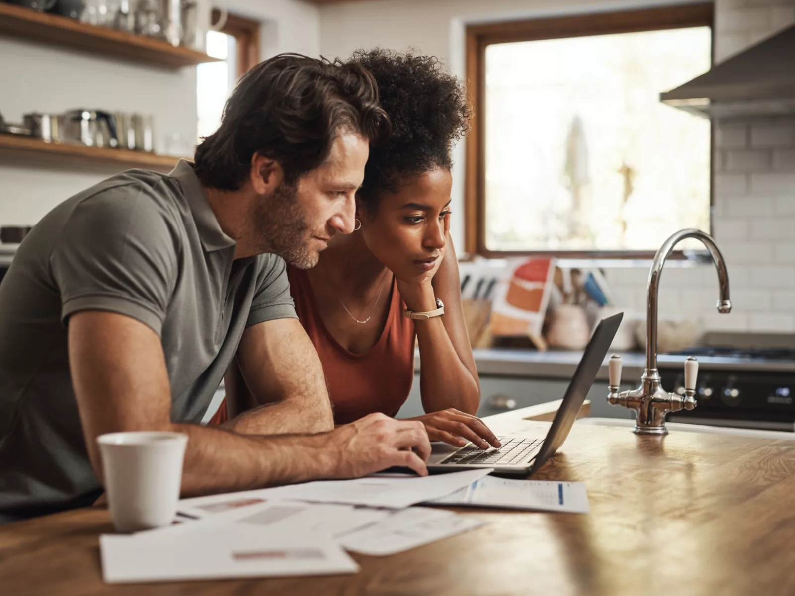 Man and women sitting at kitchen table reviewing bills